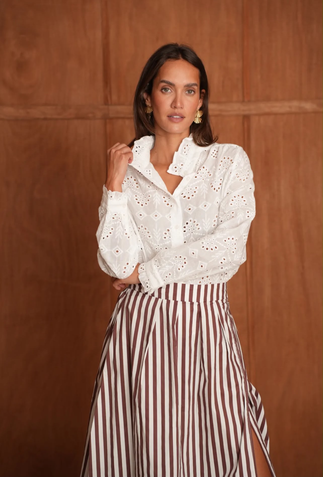 Mujer con blusa blanca y falda estampada.