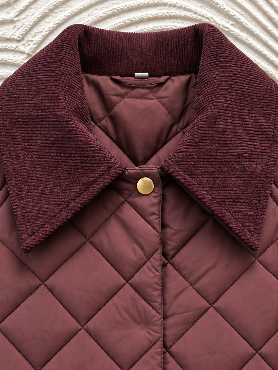 Primer plano del cuello ciruela acolchado-5 Detalle del cuello de pana y acolchado de rombos de la chaqueta berenjena
