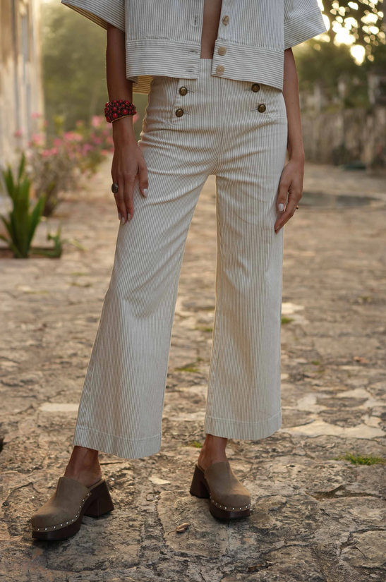 Modelo conpantalón de rayas y botones